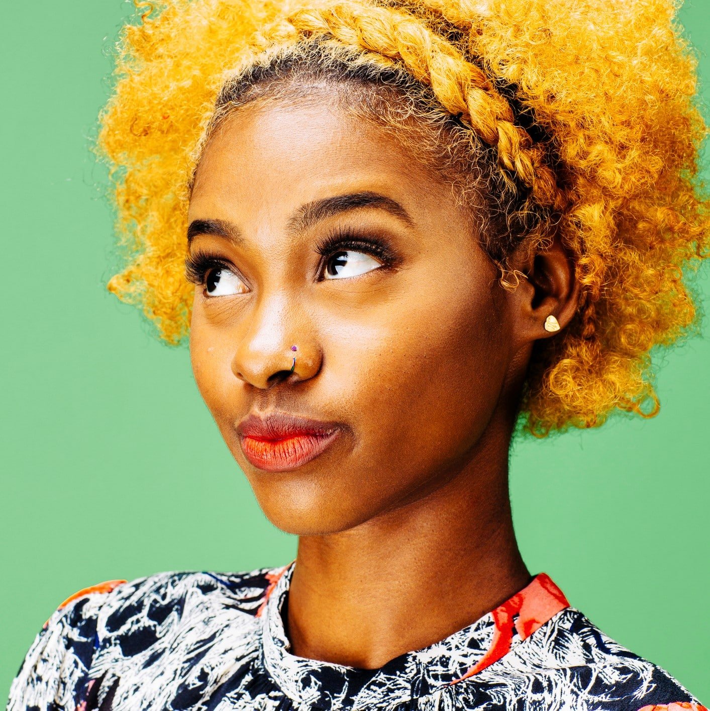 Stylish young girl with bleached curly hair looking up